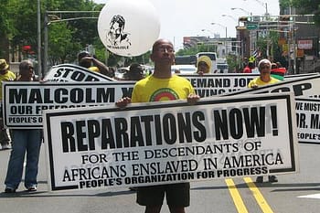 Man holding sign during Reparations for slave descendants March